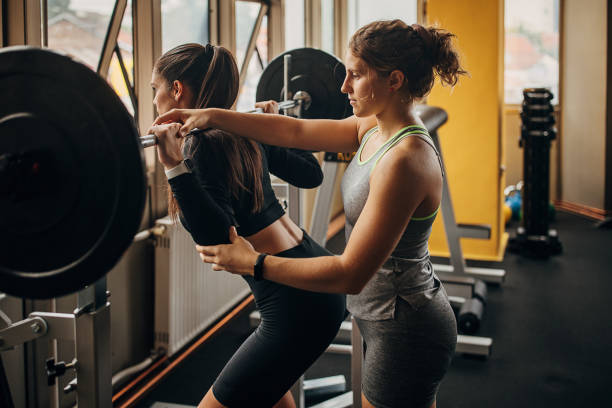 istock Personal trainer assisting a woman in training 1346316715
