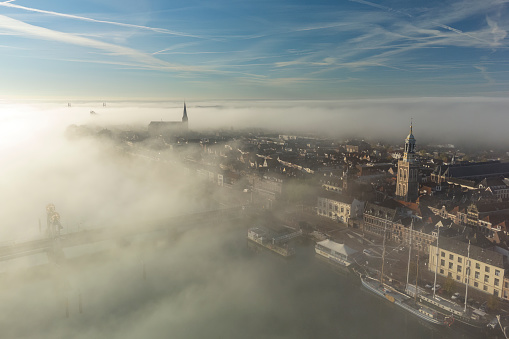 Kampen city view at the river IJssel during a foggy sunrise at the start of an autumn day with mist and blue skies.Kampen is an ancient Hanseatic League city at the shore of the river IJssel in Overijssel, The Netherlands.