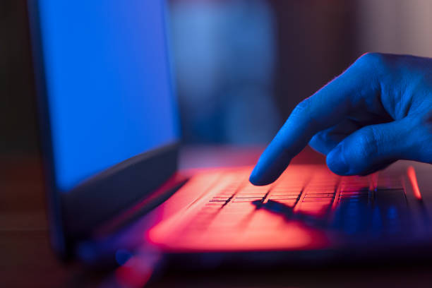 istock Man using laptop in the dark with screen glow 1346322436