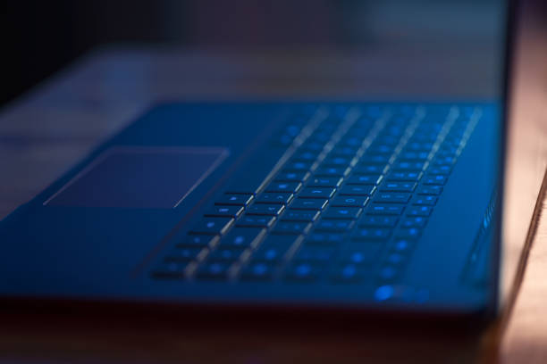 istock Laptop in the dark with blue glow of screen 1346322521