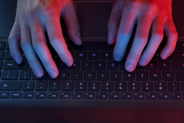 Man using laptop in the dark with screen glow