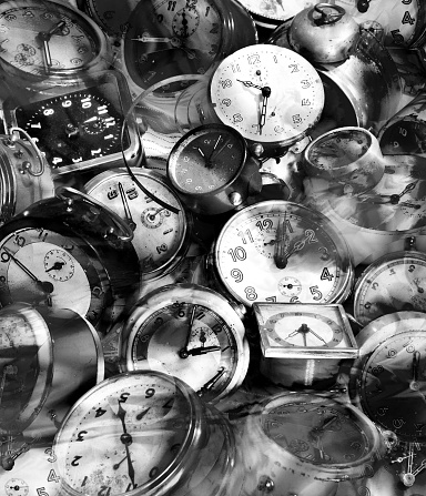 Grungy heap of alarm clocks in black and white