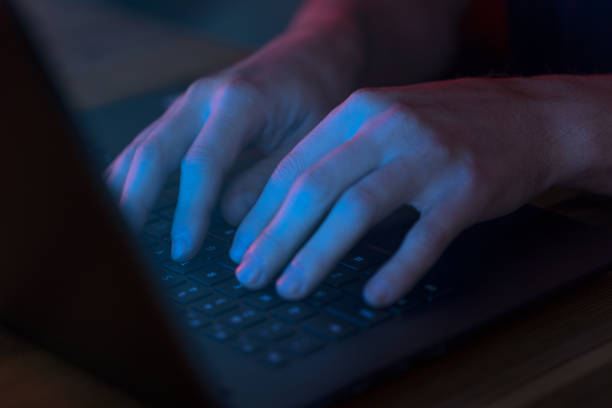 istock Man using laptop in the dark with scree glow 1346323387