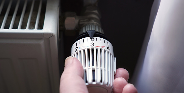 bajar el termostato del radiador para ahorrar energía debido al aumento del precio del costo de la calefacción photo