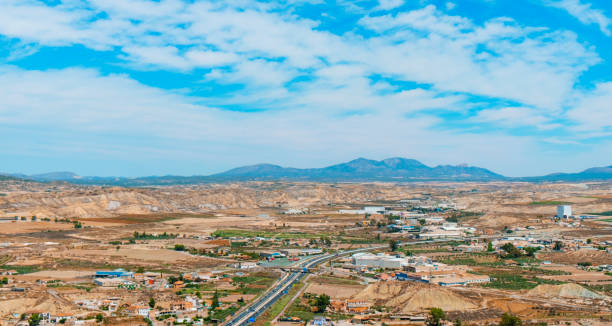 panoramic view of Lorca, in Spain a panoramic aerial view of some cultivated fields and the industrial zone of Lorca, in the Region of Murcia, Spain, highlighting the Sierra Espuna mountain range in the background lorca stock pictures, royalty-free photos & images