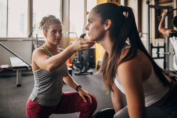 istock Fitness trainer assisting a woman in training 1346324989