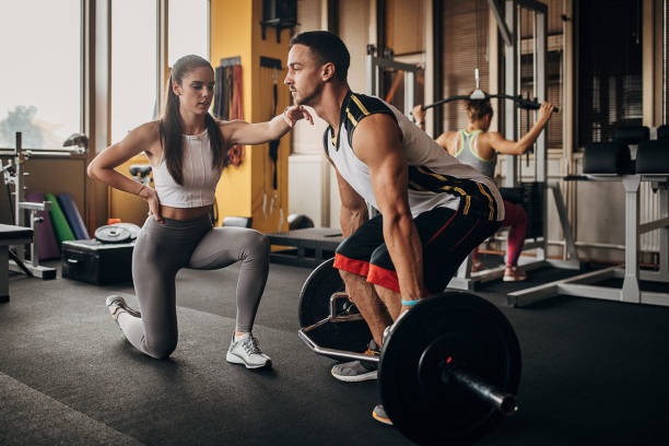 istock Fitness trainer assisting a man in training 1346326155