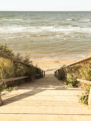 Wooden staircase through the dunes to the Black Sea beach. Minimal, natural tones, natural background.