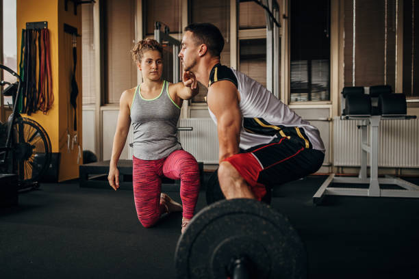 istock Personal trainer assisting a man in weightlifting 1346329492