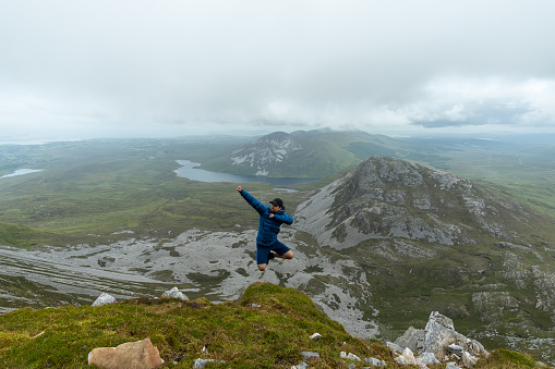 A man jumping on the top of Errigal mountain Co. Donegal, Ireland