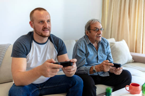 istock Elder man playing video game console with his son. 1346330602