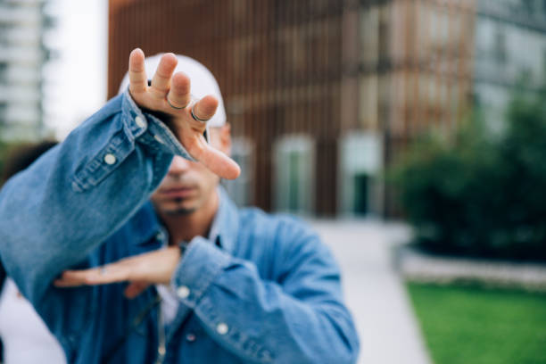 Young alternative man dressing urban clothes posing in city downtown. He is part of a group of hip hop dancers performing in the city streets.