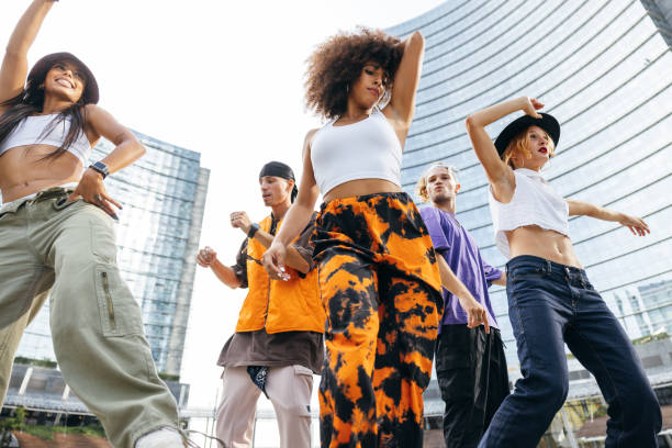 Urban dancing lifestyle, group of young performers dancing with rap music in downtown stock photo