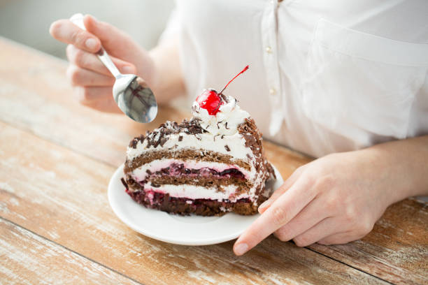 チョコレートチェリーケーキを食べる女性のクローズアップ - unhealthy eating cherry chocolate close up ストックフォトと画像