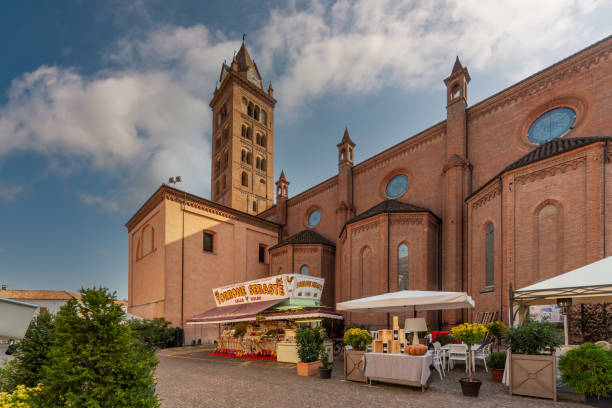 Alba, Cuneo, Piedmont, Italy - October 12, 2021: Sebaste torrone mobile stalls selling Nougat and traditional sweets in piazza Rossetti under San Lawrence cathedral bell tower at time of truffle fair