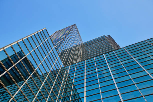 Glass building with blue sky as background。High rise glass buildings and dark steel windows, with the blue sky as the background, look for the business concept of future buildings from the perspective of corner buildings.