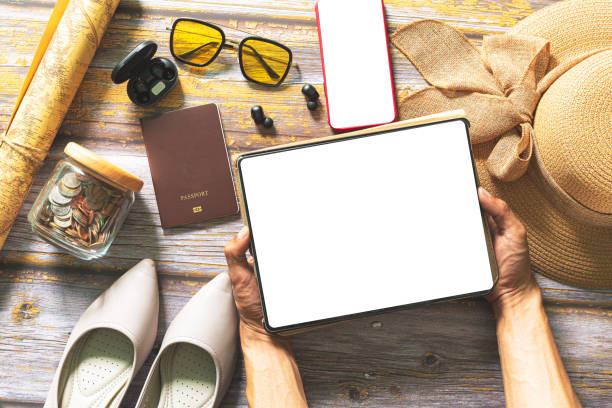 Plan a trip with a tablet,Plan a trip with a tablet,Packed suitcase of vacation items, top view,Tablet blank for mockup ecommerce concept with paying money by use credit card planifique un viaje con una tableta, planifique un viaje con una tableta, maleta empacada de artículos de vacaciones, vista superior, tableta en blanco para el concepto de comercio electrónico de maqueta con el pago de dinero con tarjeta de crédito