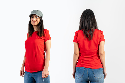Young girl wearing blank red t-shirt, cap and blue jeans. Grey wall background .