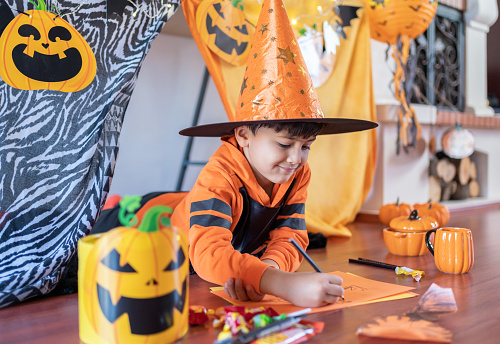 Costumed Child Ready For Halloween, Eating Sweets, Making Halloween Paper Decoration