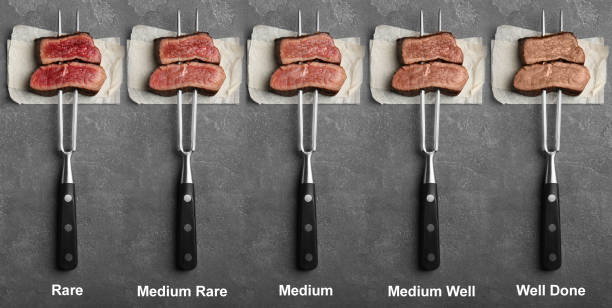 deliciosos solomillos de ternera en rodajas con diferentes grados de cocción sobre fondo gris, vista superior. diseño de banners - steak meat fork beef fotografías e imágenes de stock