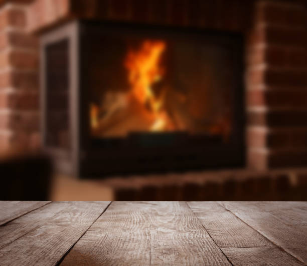 istock Rustic table and fireplace with burning wood indoors 1346339369
