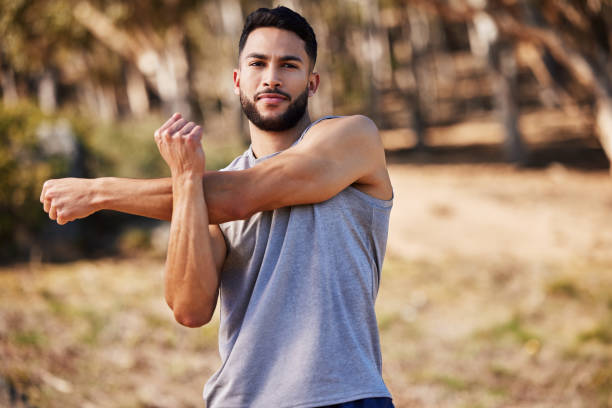 istock Shot of a handsome young man standing alone outside and stretching before going for a run 1346339521