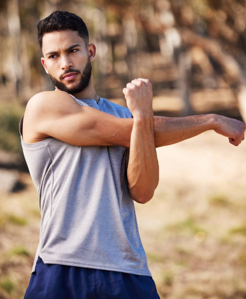 istock Shot of a handsome young man standing alone outside and stretching before going for a run 1346339534