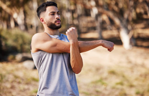istock Shot of a handsome young man standing alone outside and stretching before going for a run 1346339553