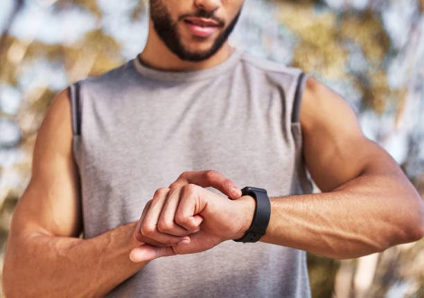 istock Cropped shot of an unrecognizable man standing alone and setting a timer on his watch before running outside 1346339579