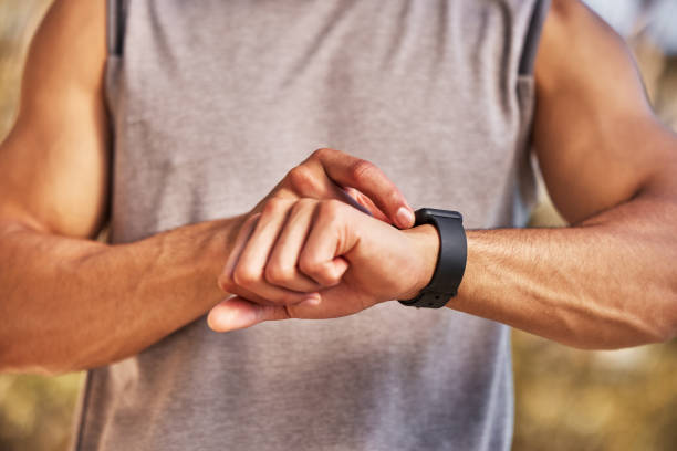 istock Cropped shot of an unrecognizable man standing alone and setting a timer on his watch before running outside 1346339595