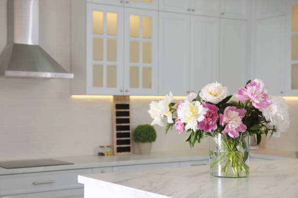 istock Bouquet of beautiful peonies on table in modern kitchen. Interior design 1346340316