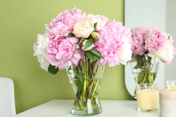 istock Beautiful peonies and candles on white dressing table near green wall 1346340558