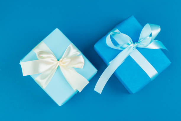istock Flat lay of gift box decorated with bow on blue background 1346340588