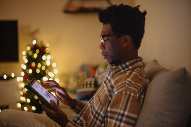 istock Young man doing online Christmas shopping on his digital tablet 1346341518