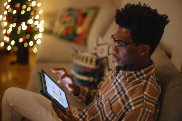 istock Young man doing online Christmas shopping on his digital tablet 1346341532