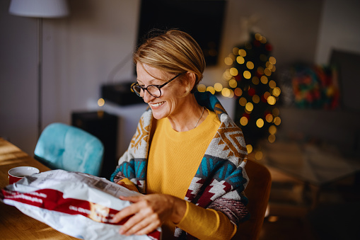 Happy woman opening online store order. Receiving gift in postal delivery shipping box