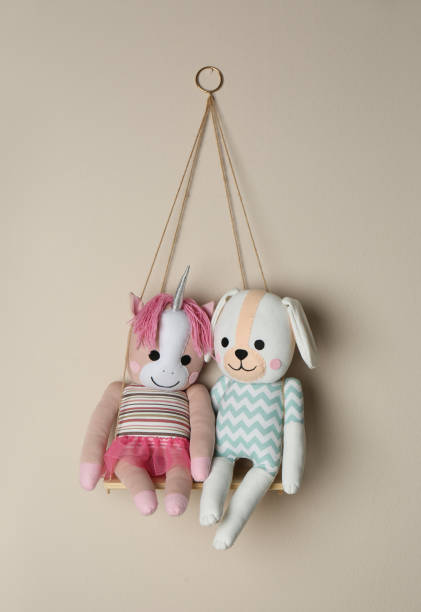 istock Shelf with cute toys on beige wall. Child's room interior element 1346341837