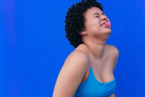 istock Funny girl blowing a balloon. 1346342035