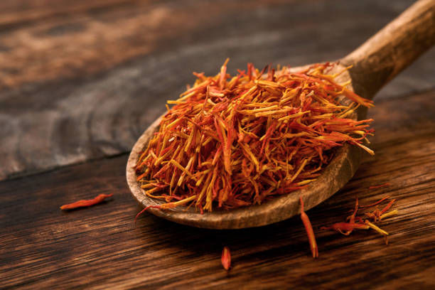 istock Red Saffron in spoon on old wooden background. Background and texture. Mock up. 1346345351