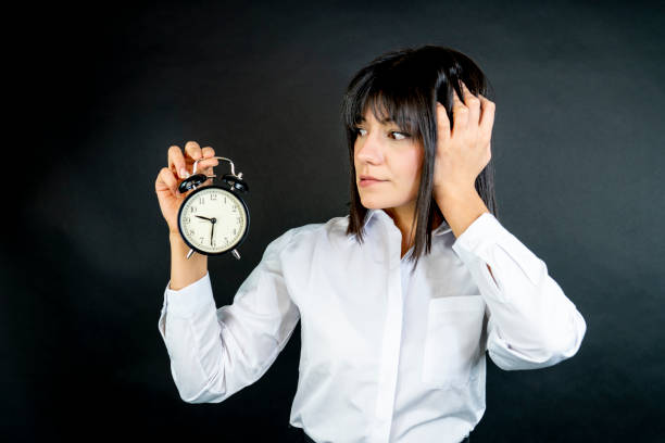 Business woman holding alarm clock. Trouble with deadline, concept