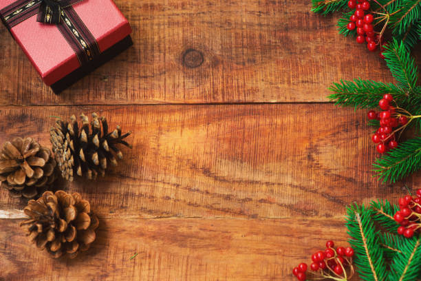 istock Christmas background. Spruce branches, gift, pinecones, red berries on a wooden background 1346347504