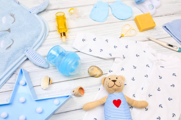 istock baby clothes and  attributes on a white wooden background. View from above 1346349321