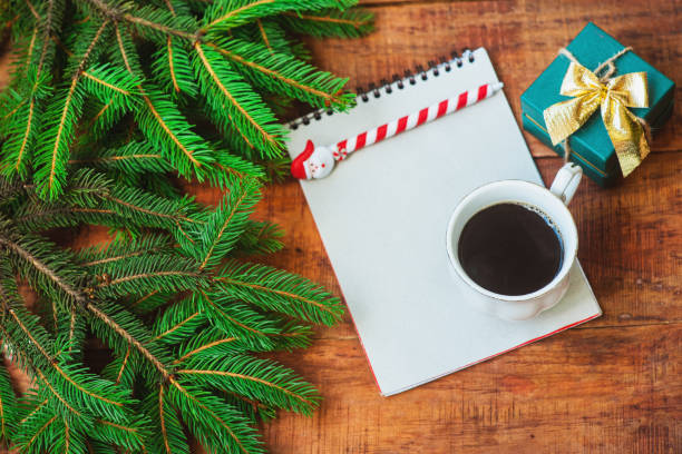 istock Christmas background. Spruce branches, notebook, gift and cup with coffee on a wooden background. 1346349621