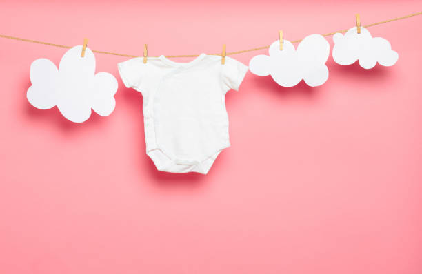 istock Baby clothes on a clothesline on pink background - Image 1346349903