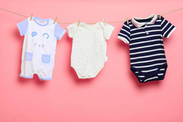 istock Baby clothes on a clothesline on pink background - Image 1346349917