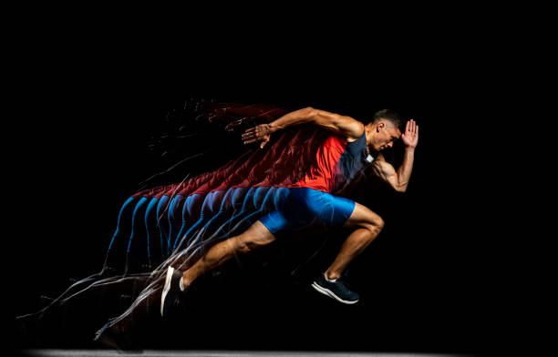 Full-length portrait of young male athlete, professional runner in motion isolated over black background. Stroboscope effect. Developing strength. Young male athlete, professional runner in motion isolated over black background. Stroboscope effect. Concept of sport, action, energy, health, movement. Copy space for ad temporal aliasing stock pictures, royalty-free photos & images