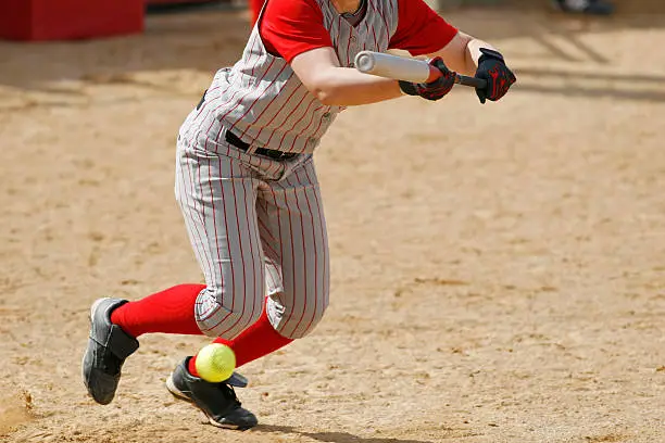 A woman bunting in softball.