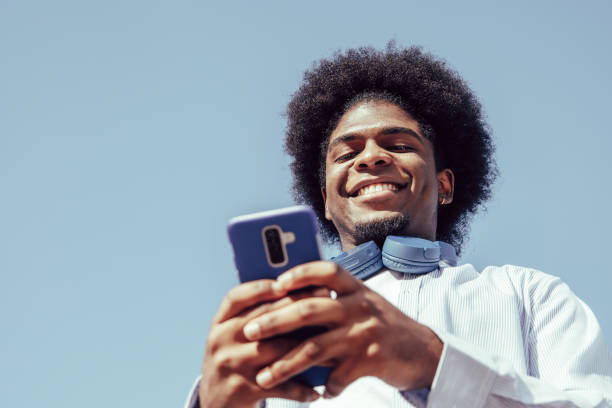 istock Happy young african american man using smartphone and smiling 1346355087