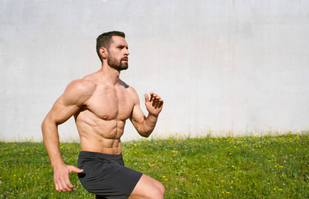 athletic man training outdoors doing skip exercise - shirtless energy action effort imagens e fotografias de stock