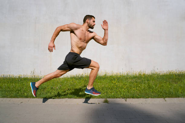 athletic man sprinting against concrete all in the city - shirtless imagens e fotografias de stock
